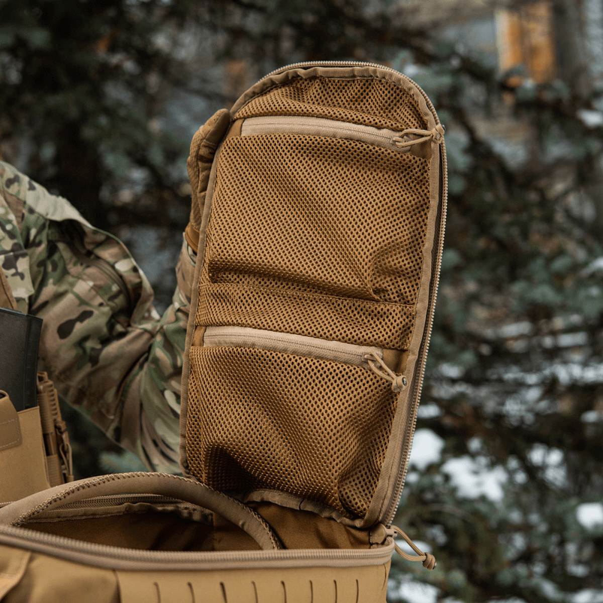 M-Tac Rygsæk Sturm Elite Gen.II med åbnet kuffertstil rum og to netlommer til EDC-udstyr udenfor i et skovmiljø.