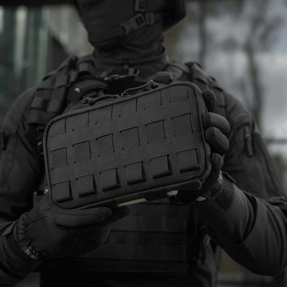 Person holder M-Tac Admin Pouch Large Elite i sort, funktionel taske til taktisk udstyr lavet af Cordura 500D med velcro og laserudskæringer.