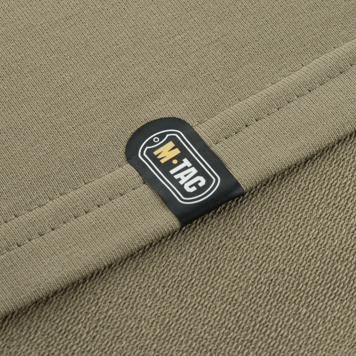 Nærbillede af M-Tac Pullover 4 Seasons'etiket på minimalistisk, alsidigt design til helårsbrug. Materiale: 95% bomuld, 5% elastan.
