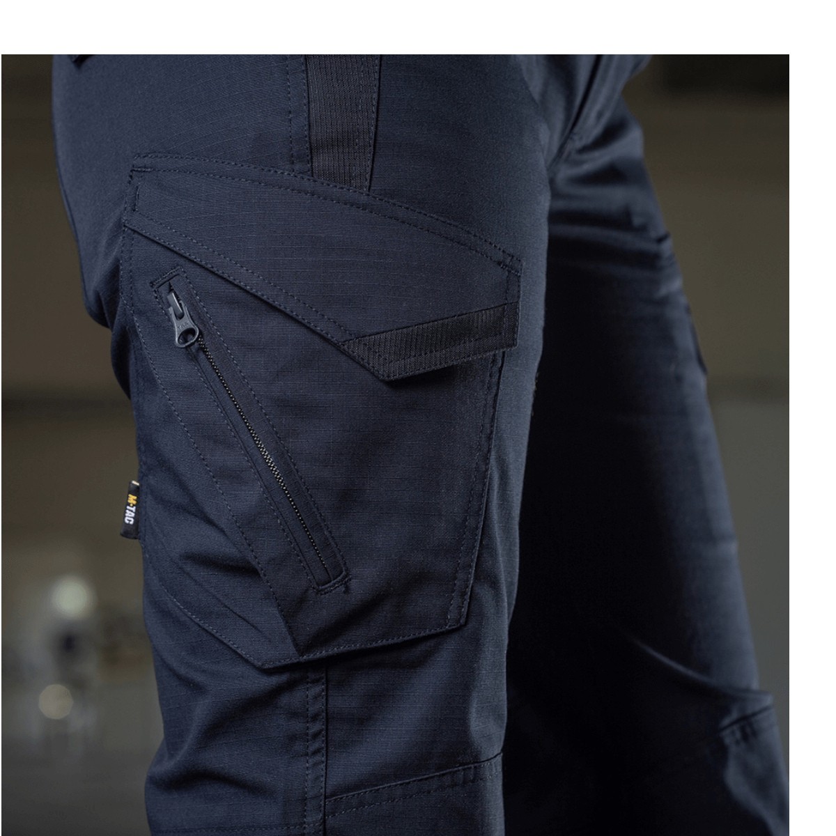 Nærbillede af M-Tac Bukser Aggressor Dame Flex i sort med lynlåslomme, designet til træning og udendørs aktiviteter