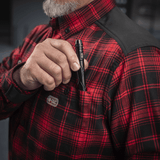 Person iført M-Tac Redneck Skjorte i rød plaidmønster med en lommepen i brug. Fremhævet for styrke og komfort.