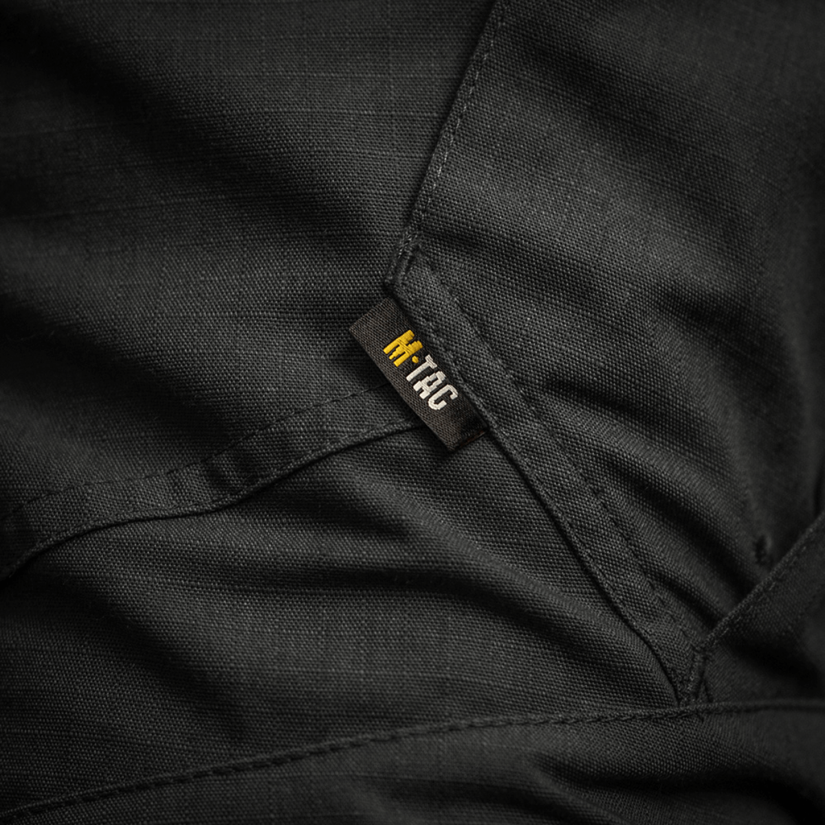 Detalje af M-Tac Bukser STURM NyCo Extreme Gen.II med robust syning og mærke. Materiale NYCO Extreme for holdbarhed og komfort.