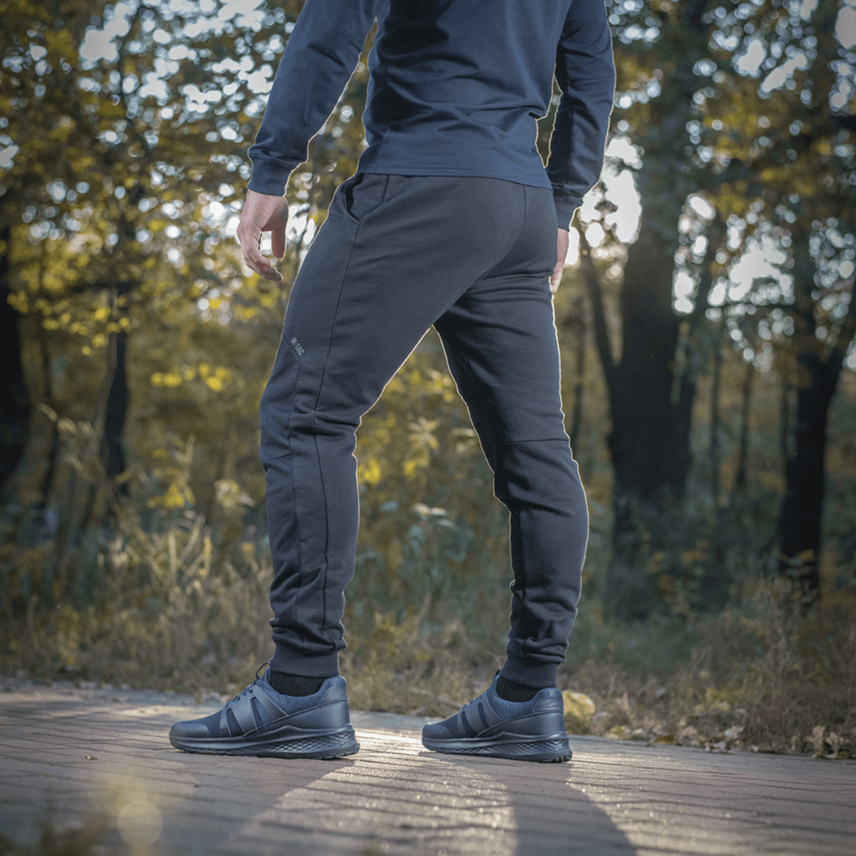 Mand iført M-Tac Bukser Stealth Cotton, sportsbukser i 100% bomuld, perfekt til løb og hverdag.