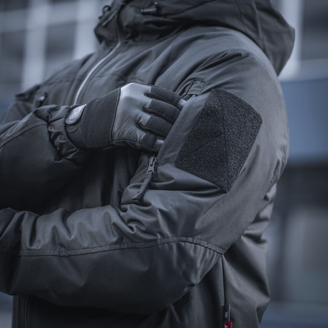 Person iført M-Tac Alpha Gen.III Pro Vinterjakke med justerbar hætte, forstærkede albuer, og G-Loft isolering for kølige temperaturer.