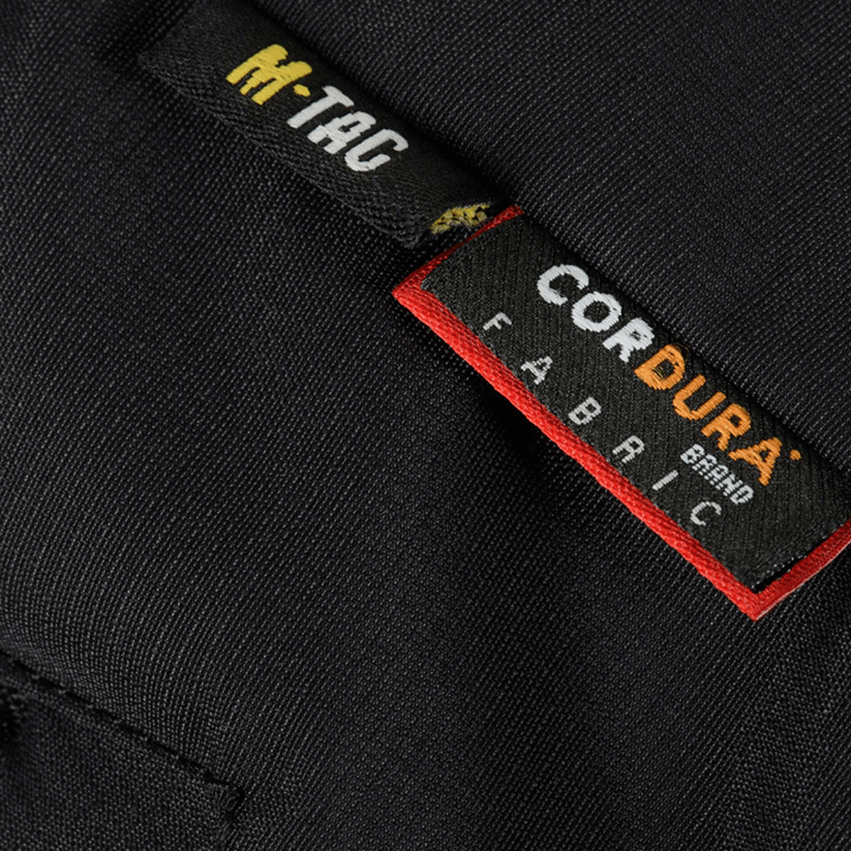 Etikette af M-Tac Alpha Gen.III Pro Vinterjakke med Cordura-stof, der viser holdbarhed og kvaliteten af materialevalg.