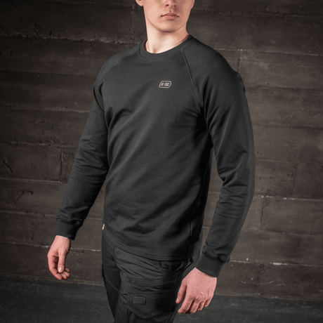 Mand iført M-Tac Raglan Athlete sweatshirt i sort med raglanærmer, perfekt til sport og hverdagsbrug, set fra brystet og op.