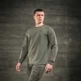 Mand iført M-Tac Raglan Athlete sweatshirt med raglanærmer i oliven farve, velegnet til både sport og hverdag.