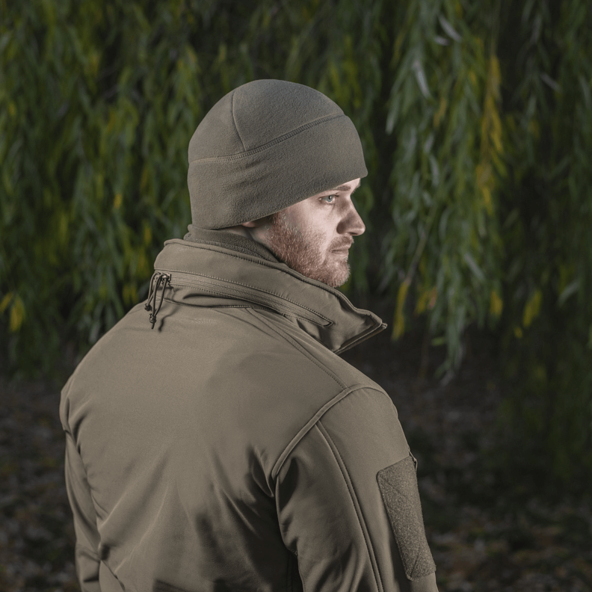 Mand iført M-Tac Fleece Polartec Watch Cap i udendørs miljø, beskytter mod kulde, ideel til vinterbrug