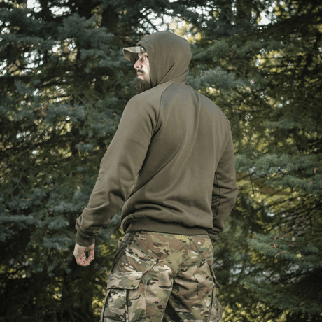 M-Tac Cotton Raglan Hard Hoodie i skovmiljø med stilfuldt design, kængurulomme og raglanærmer, perfekt til udendørs brug.