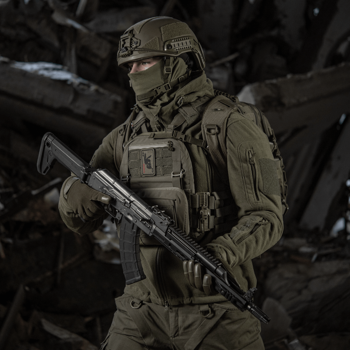 Taktisk soldat i kampuniform med gevær i ruiner.