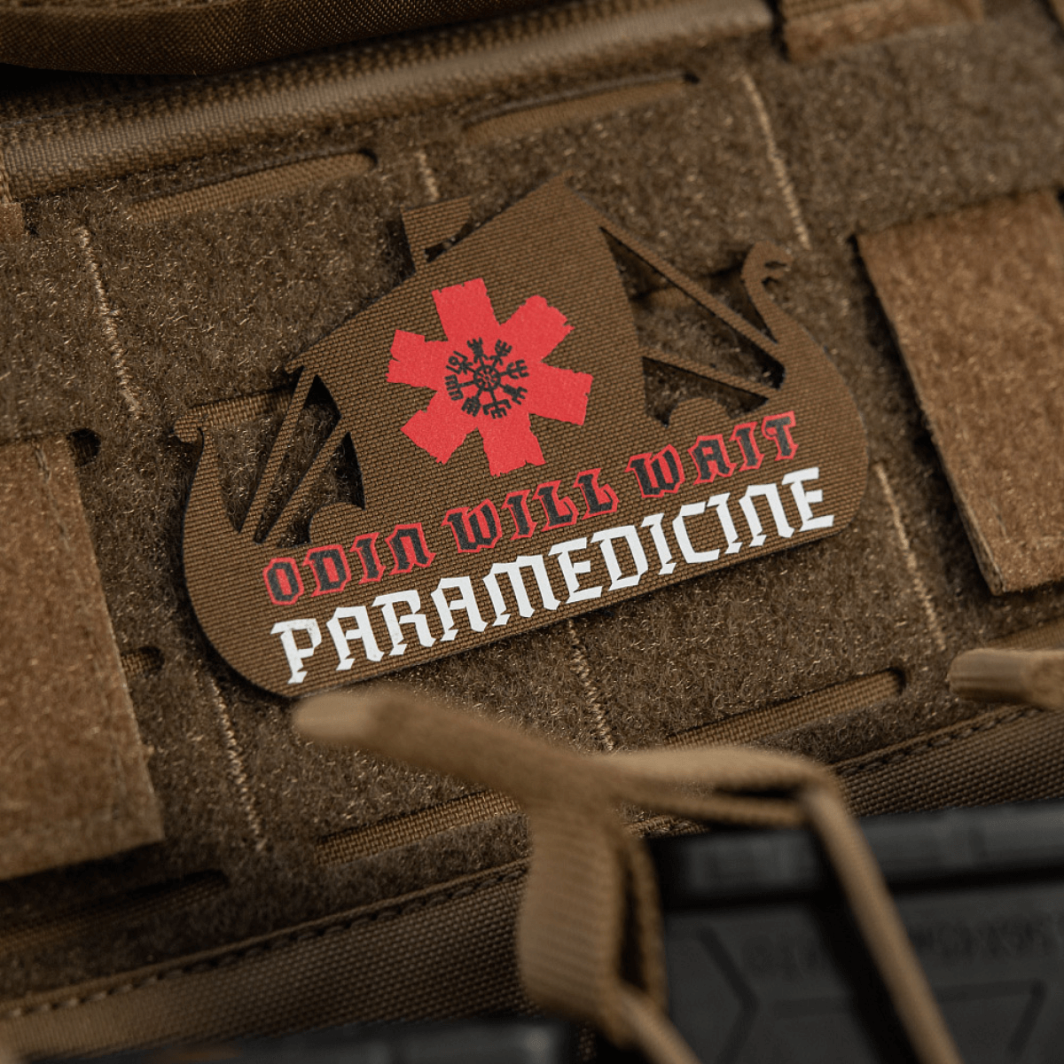 M-Tac Patch Viking Evac i brun farve formet som et skib, med rød paramedicinsk stjerne og tekst på en taktisk rygsæk.