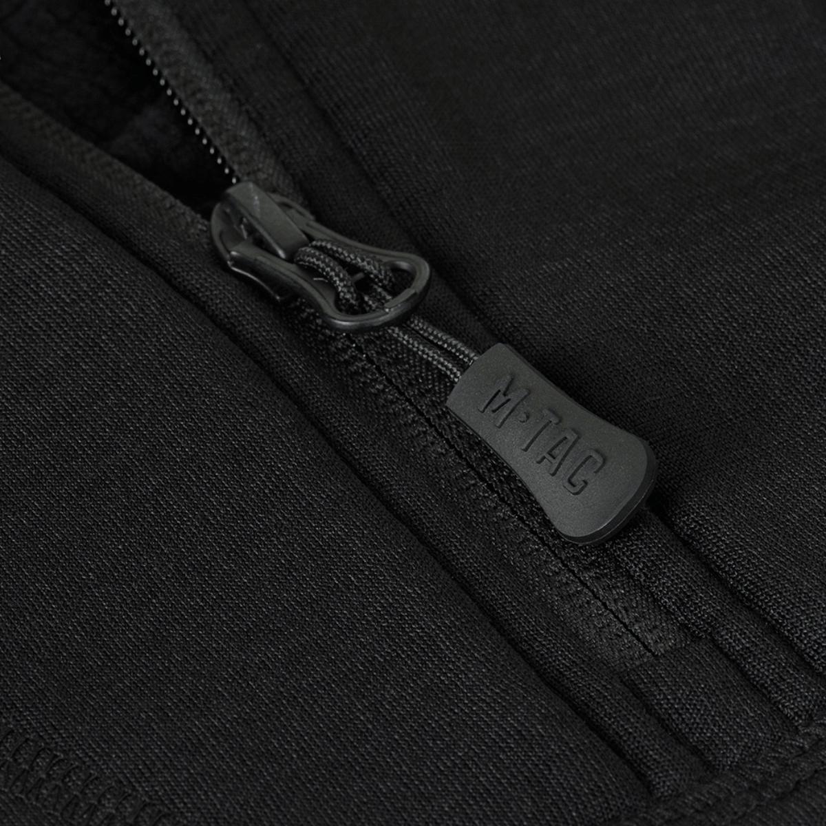 Nærbillede af lynlås på M-Tac Thermal Fleece Shirt Delta Level 2 Lady, fremstillet af varmebevarende polyester materiale.