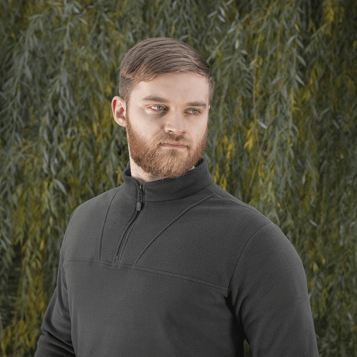 Mand iført M-Tac Delta Polartec Fleecejakke foran en grøn baggrund