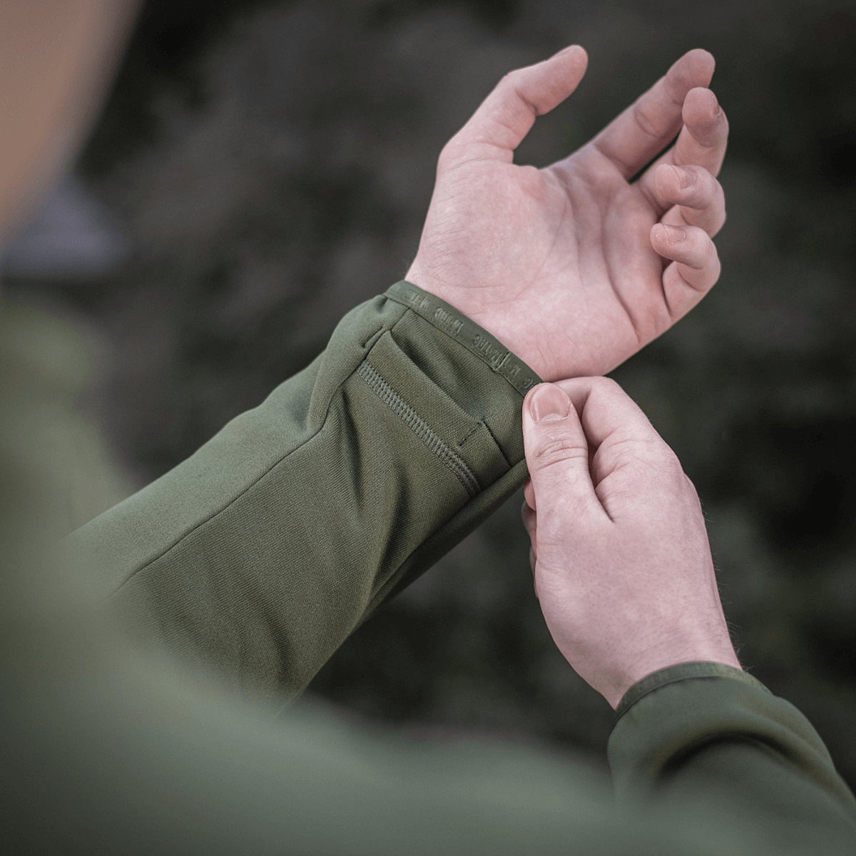 Nærbillede af en person iført M-Tac Polartec Sport Fleecejakke, der viser jakke ærmets design og materialekvalitet.