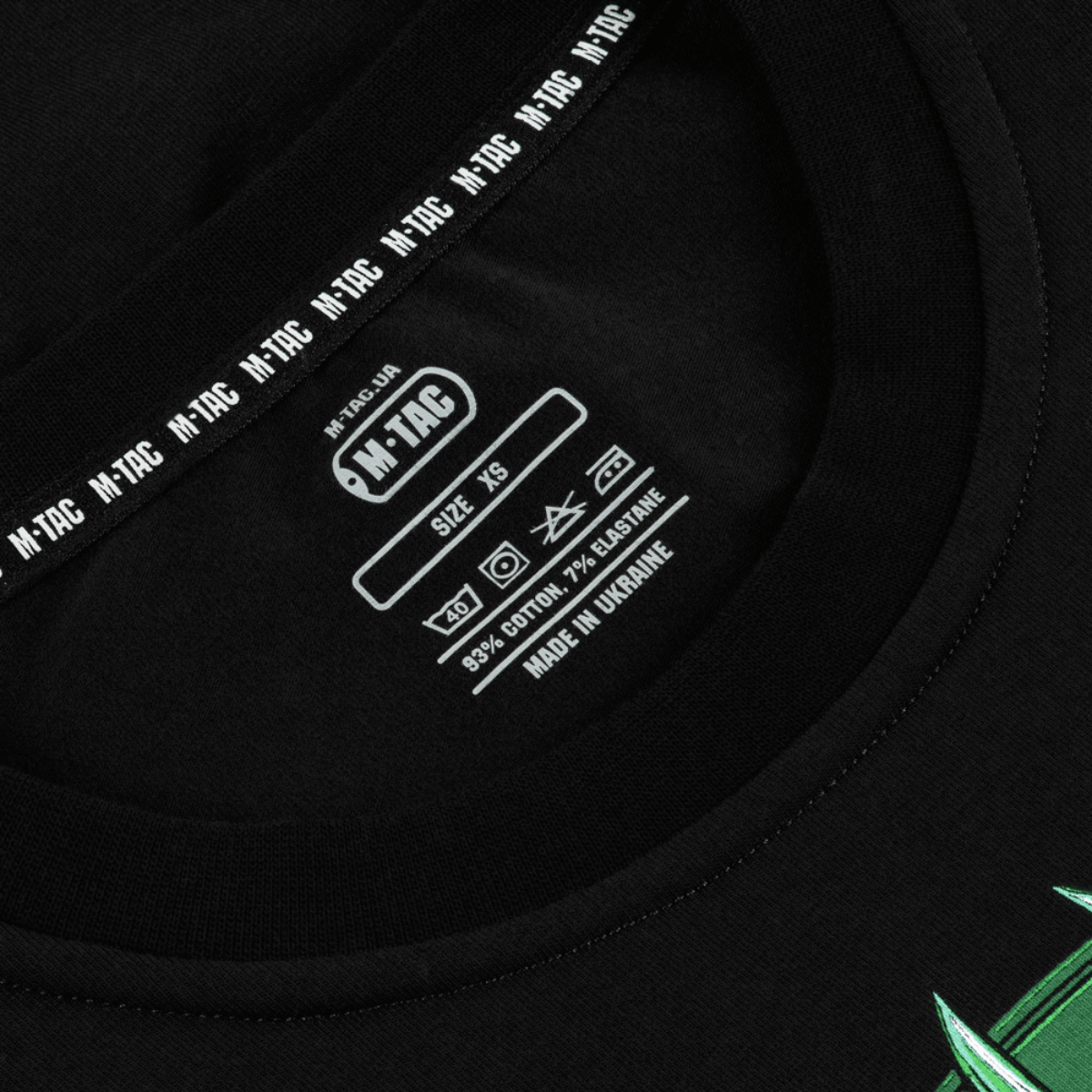 Nærbillede af etiketten på M-Tac T-Shirt Night Vision i sort, lavet af bomuldsblanding, med tydelige vaskeanvisninger og størrelse XS.