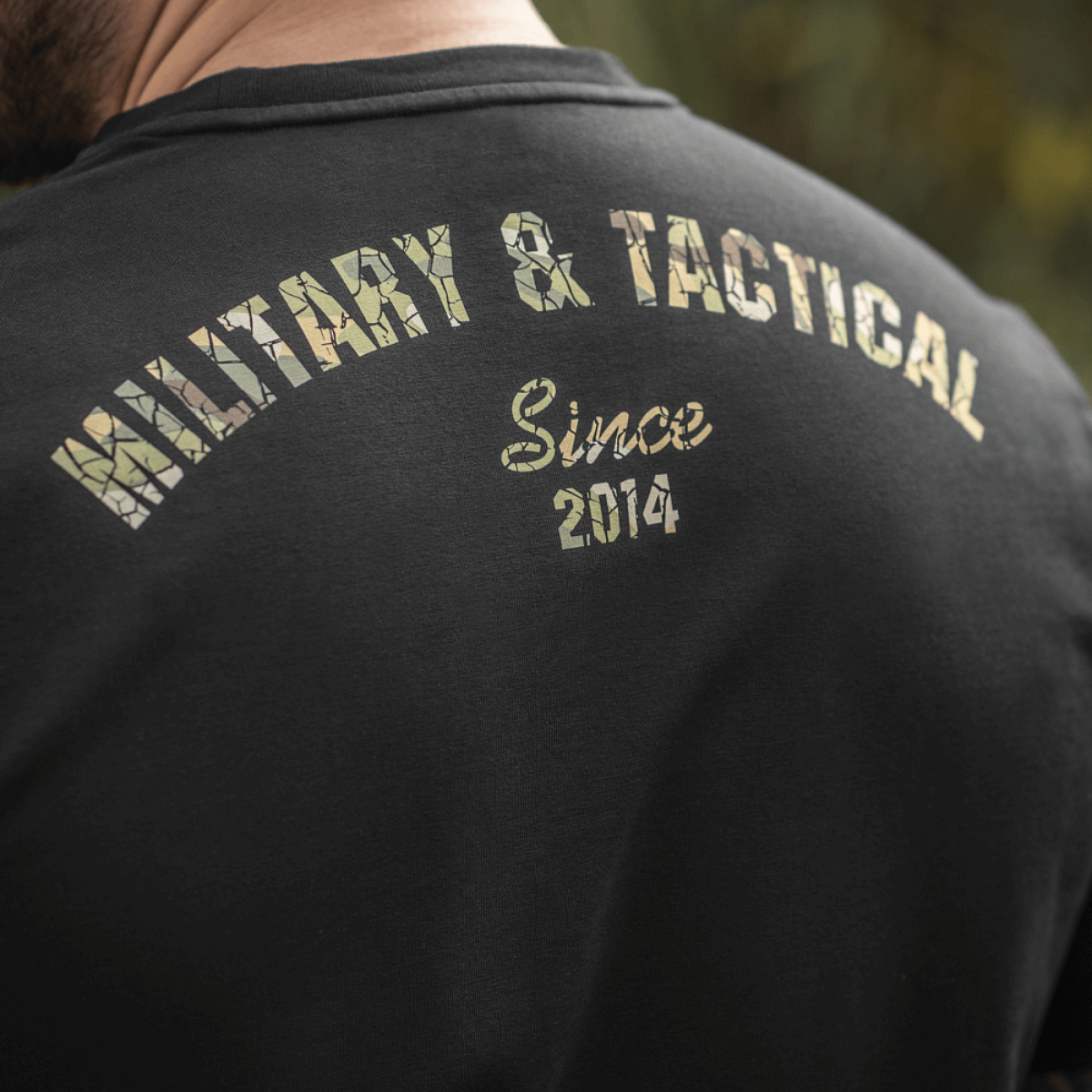 M-Tac T-Shirt Logo med "Military & Tactical Since 2014" camouflage print på ryggen, symboliserer brandets taktiske arv.
