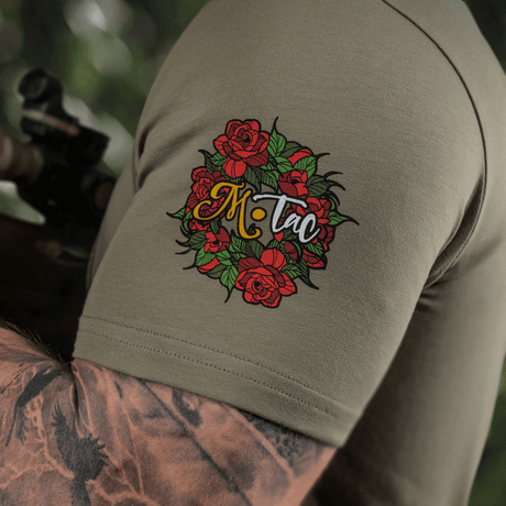 M-Tac T-Shirt Motanka med blomsterdesign på ærmet, fremhæver ukrainsk kulturarv og moderne stil i olivengrøn.