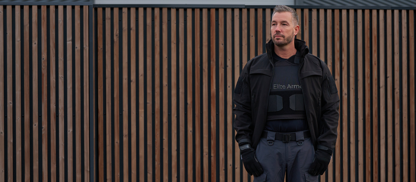 Mand iført Elite Armor RX2 skudsikker vest står ved port i professionelt sikkerhedsmiljø