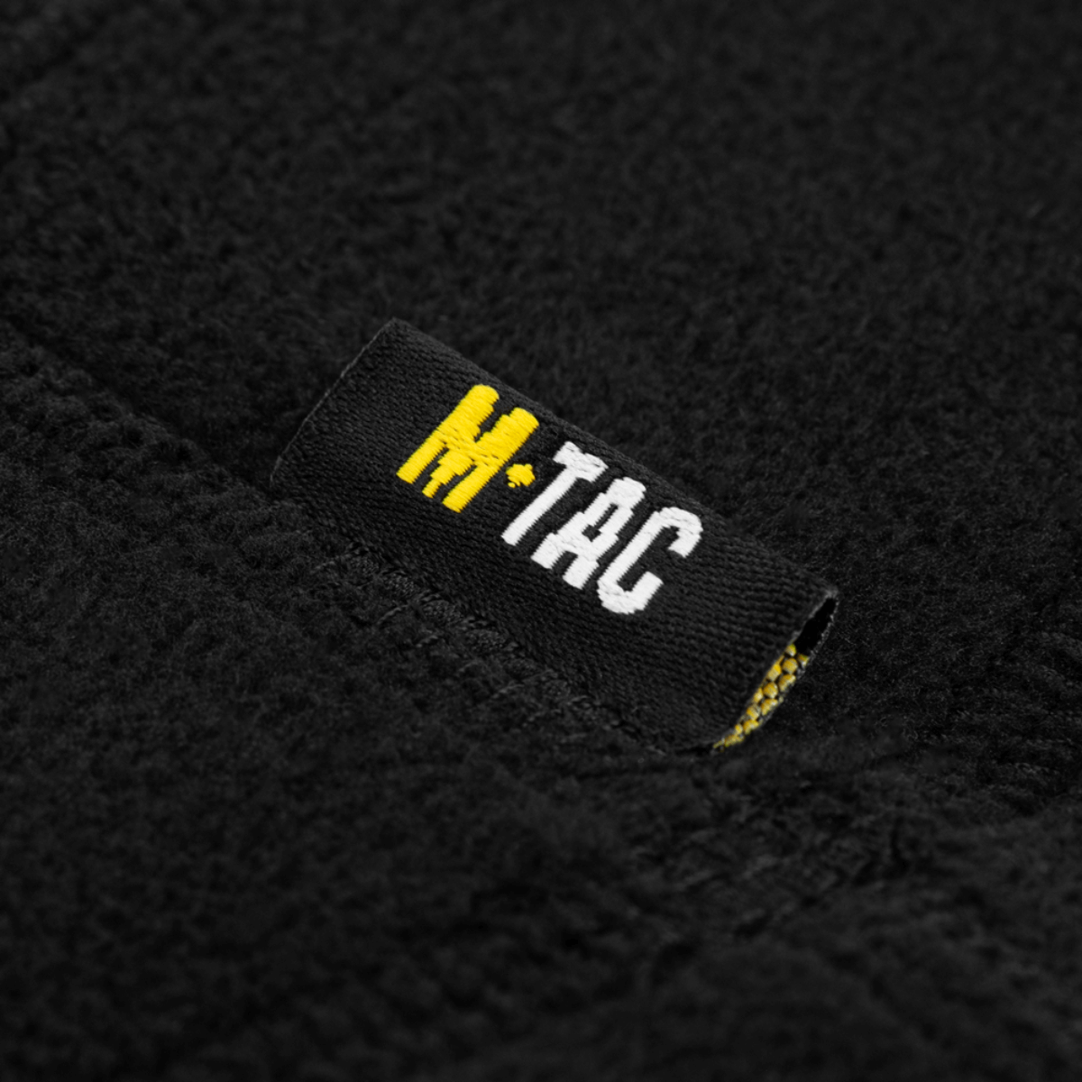 M-Tac Anatomisk Snood Justerbar Elite Fleece (320 g/m²) detalje af mærkat på sort fleece materiale