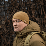 Mand iført M-Tac Fleece Watch Cap Light Polartec hue i brune toner, velegnet til vinterbeskyttelse mod kulde og vind.