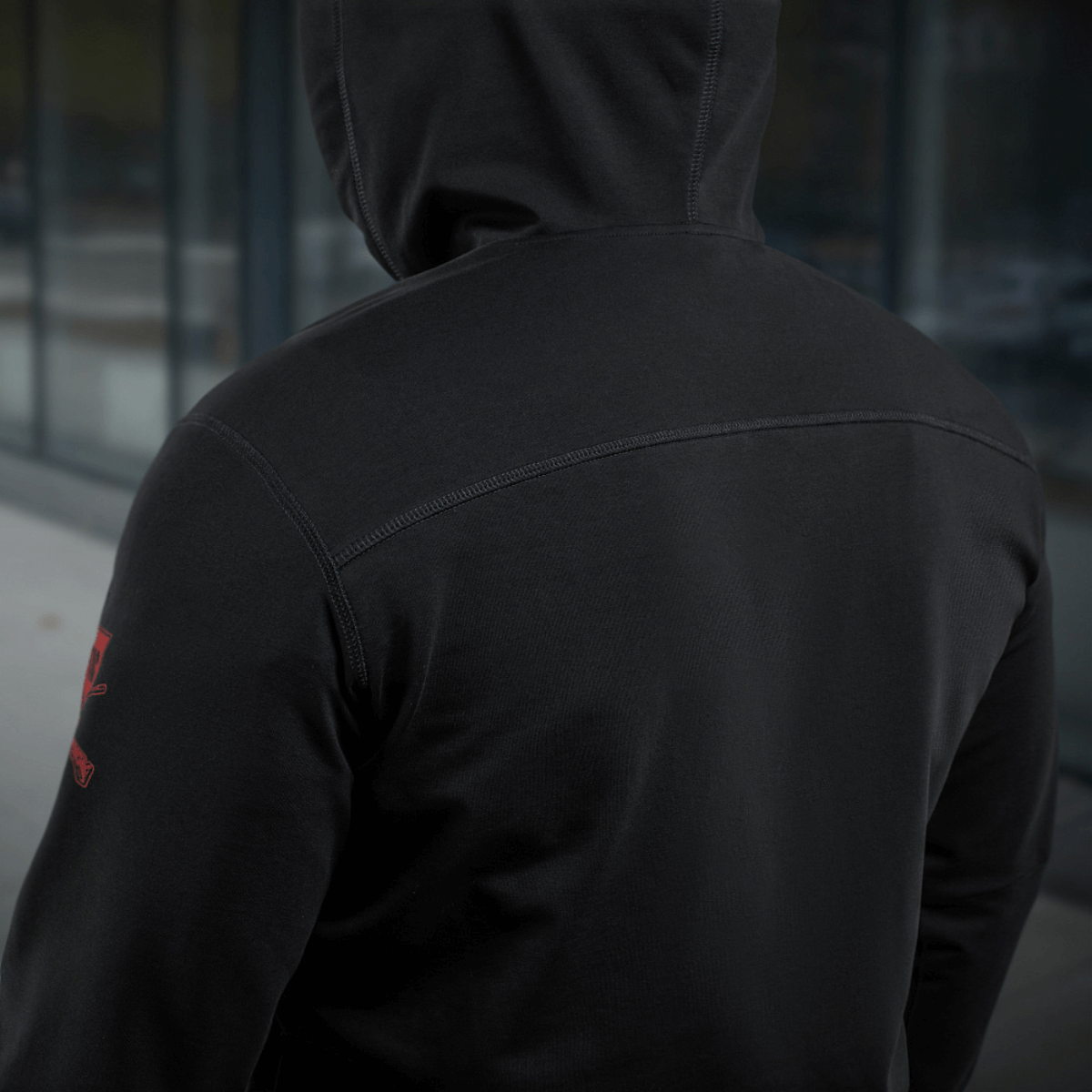Person i M-Tac Hoodie Freedom med militærinspireret design, set bagfra for at vise rygdetaljer, ideel til udendørs aktiviteter.