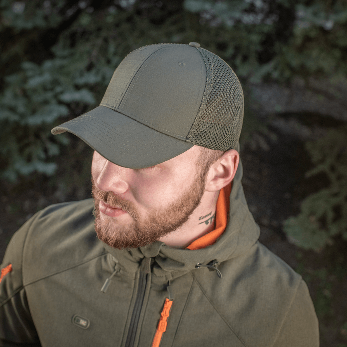Mand iført M-Tac Mesh Flex Ripstop Baseball Cap med mesh-paneler til ventilation udendørs i naturmiljø.