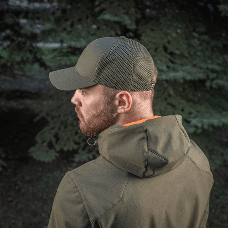 Mand iført M-Tac Mesh Flex Ripstop Baseball Cap i skov, viser justerbar Velcro-strop og mesh-paneler for ventilation.