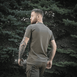 Mand iført M-Tac Sniper T-shirt i skovmiljø, bagfra, viser pasform og tætsiddende design