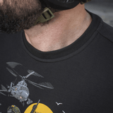 Mand iført M-Tac T-Shirt Surf Club, med design inspireret af ukrainske specialoperationer og surfscener, viser tæt på trykket.