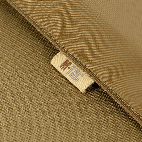 Mærkat på M-Tac taske til Bundeswehr liggeunderlag i nærbillede, viser holdbart materiale og M-Tac branding.