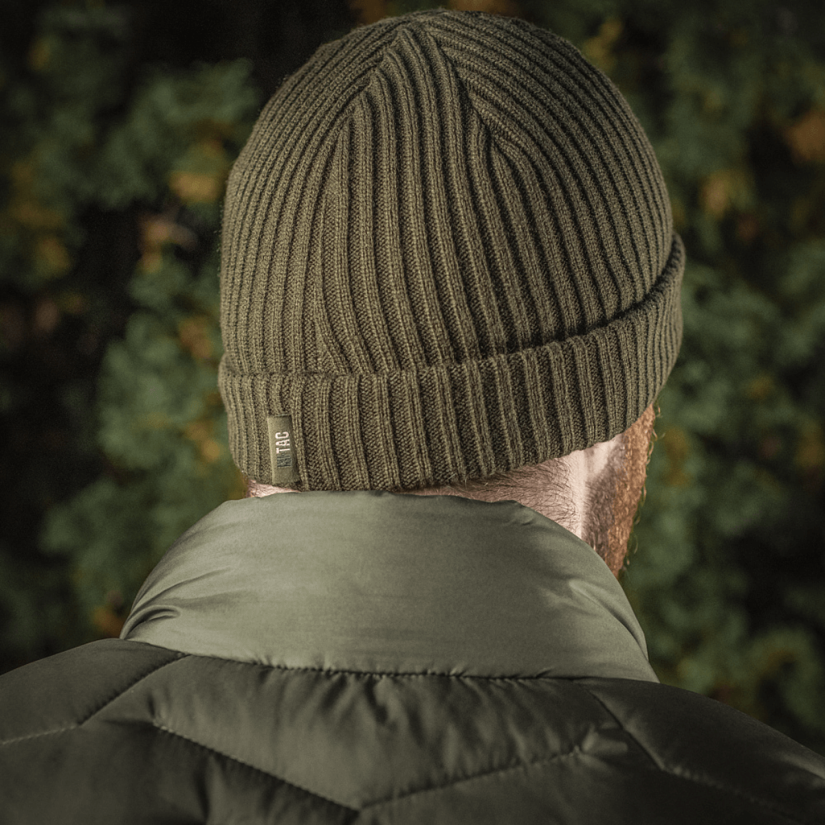 M-Tac Watch Cap 100% Akryl strikket i olivengrøn farve, ideel til køligt vejr, viser lav pasform og dobbelt opslag for ekstra varme.