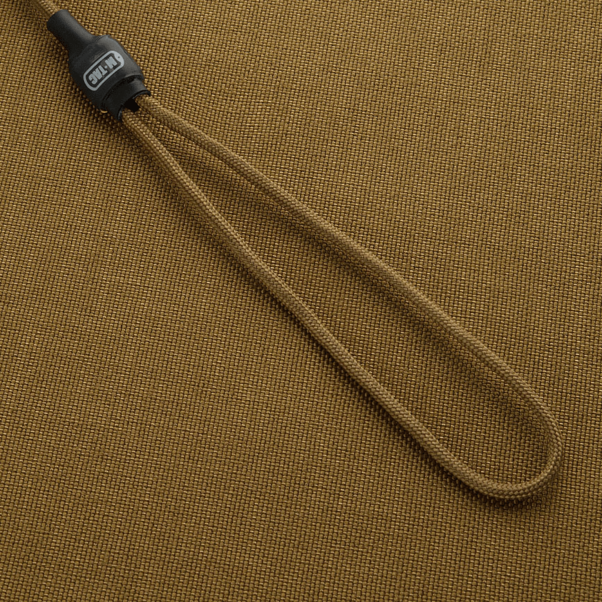 M-Tac Safety Cord Medium Universal fastgjort på beige baggrund, fleksibel spiralkonstruktion til sikring af udstyr.