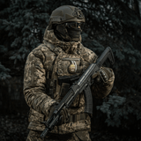 Soldat iført camouflagejakke med M-Tac Patch M67 Granat 3D PVC på vest under militæroperation i skov.